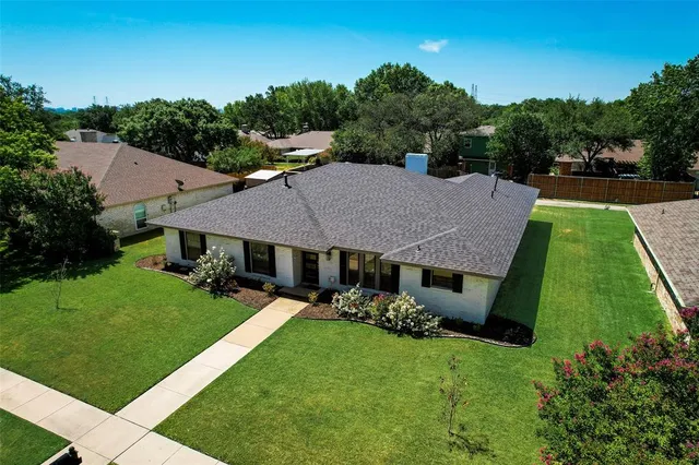 a aerial view of a house with table and chairs under an umbrella