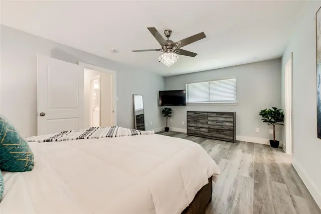 a bed sitting in a spacious bedroom next to a bathroom