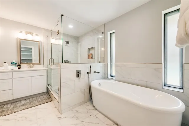 a bathroom with a tub shower and sink