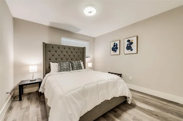 a spacious bedroom with a bed and wooden floor