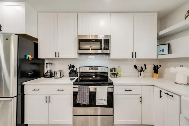 a kitchen with white cabinets stainless steel appliances and sink