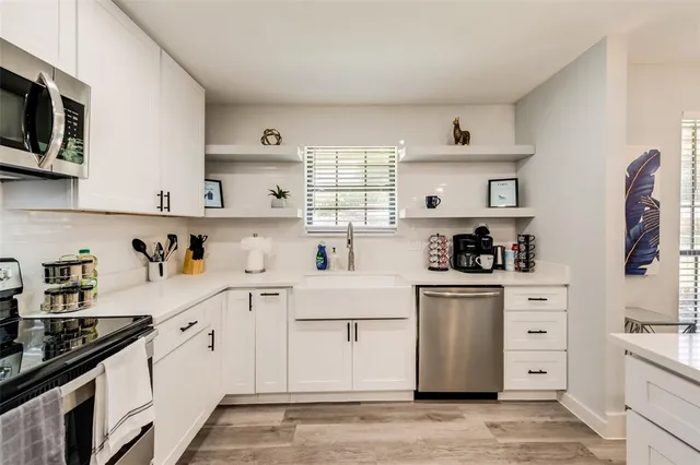 a kitchen with white cabinets stainless steel appliances and sink