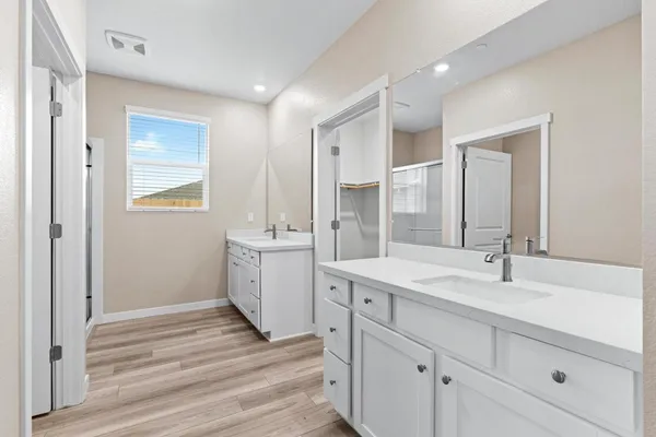 a spacious bathroom with a double vanity sink a mirror and a