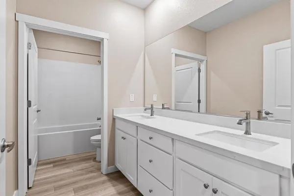 a bathroom with a tub a sink and mirror