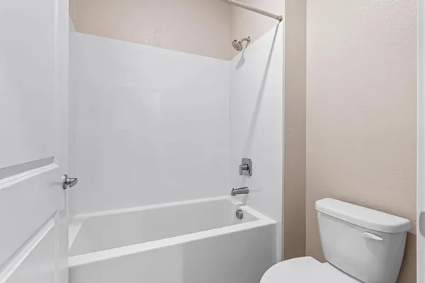 a white bath tub sitting next to a white toilet and sink