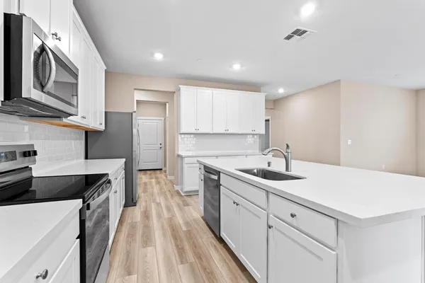 a kitchen with a sink stove and refrigerator