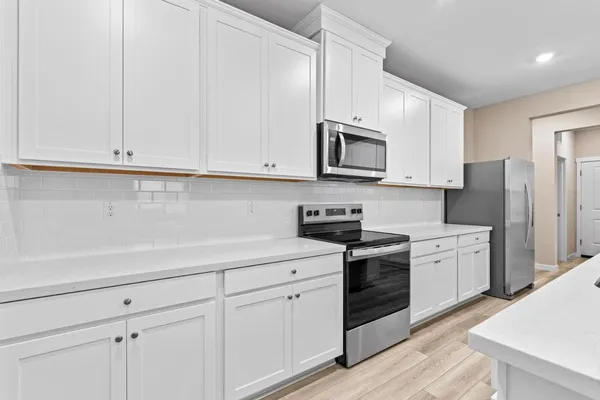 a kitchen with white cabinets and stainless steel appliances