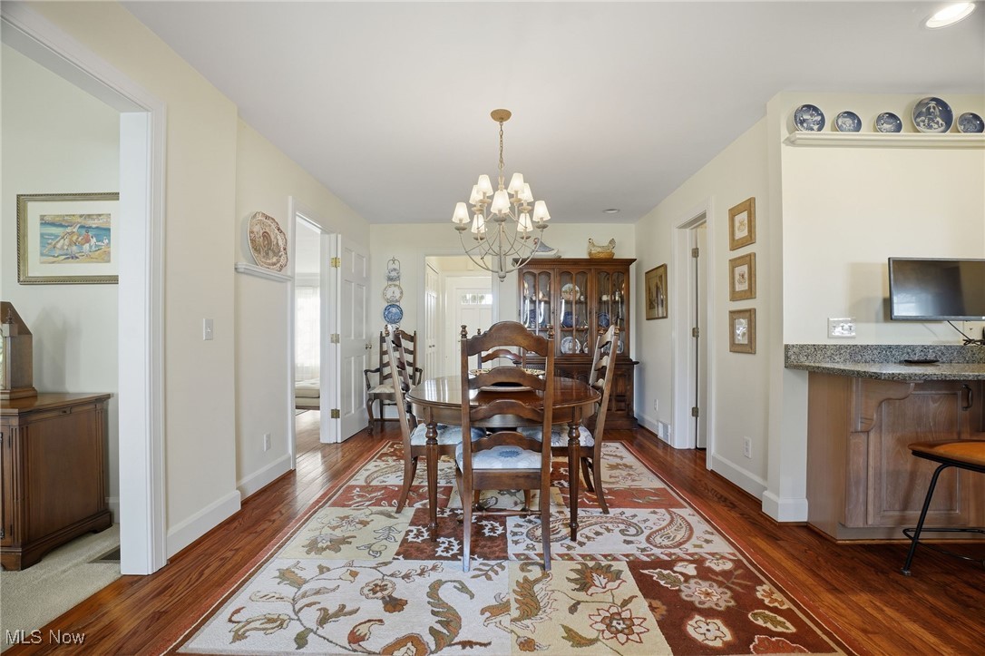 4441 Lake Road West Ashtabula, OH 44004 - Photo 13 of 46 Dining room featuring dark wood-style flooring and a chandelier