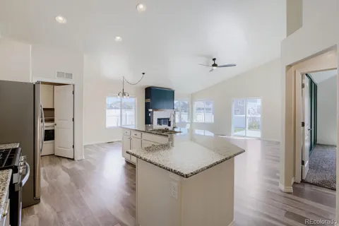 a kitchen with kitchen island a counter top space a sink stainless steel appliances and cabinets