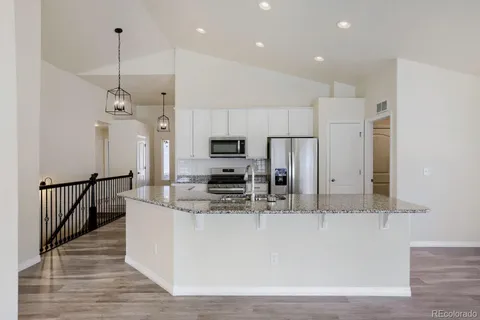 a large kitchen with stainless steel appliances granite countertop a sink a oven and a refrigerator