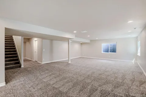 an empty room with windows and stairs