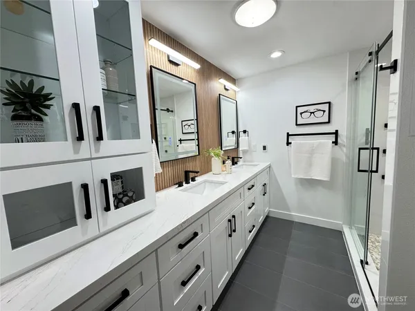 a spacious bathroom with a double vanity sink a mirror and shower