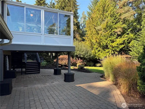 a view of a two chairs and table in the back yard of a house