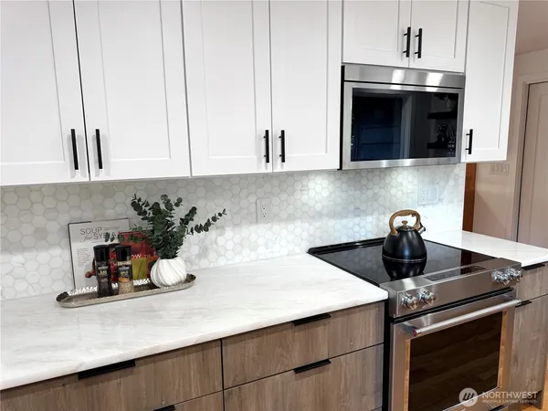 a kitchen with a stove and a white cabinets
