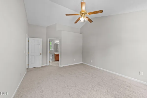 an empty room with closet and fan