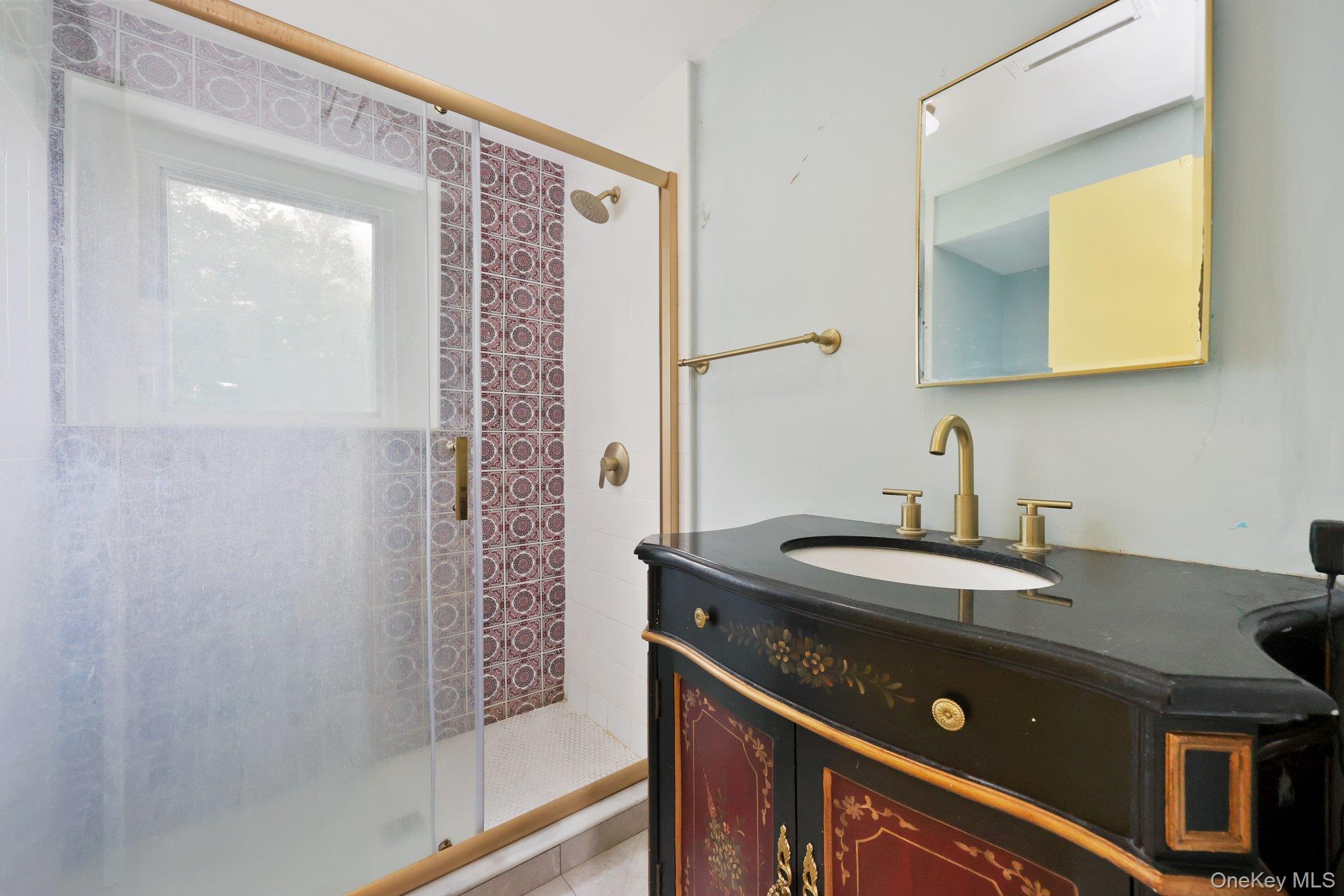 69 Cornwells Beach Road Sands Point, NY 11050 - Photo 39 of 42 a bathroom with a sink a mirror and a shower