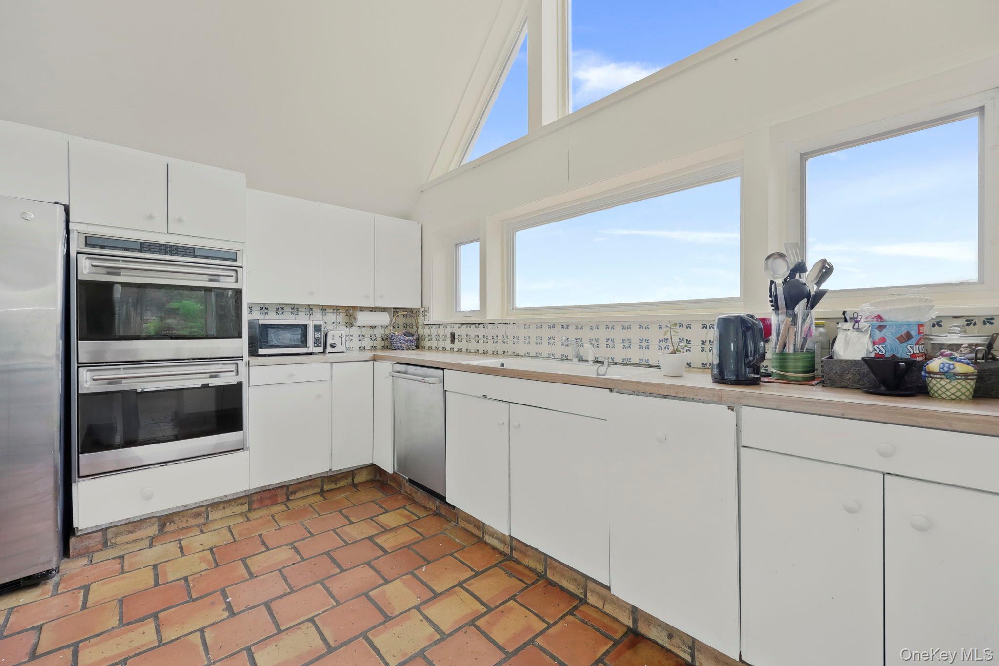 69 Cornwells Beach Road Sands Point, NY 11050 - Photo 7 of 42 a kitchen with a sink cabinets and stainless steel appliances