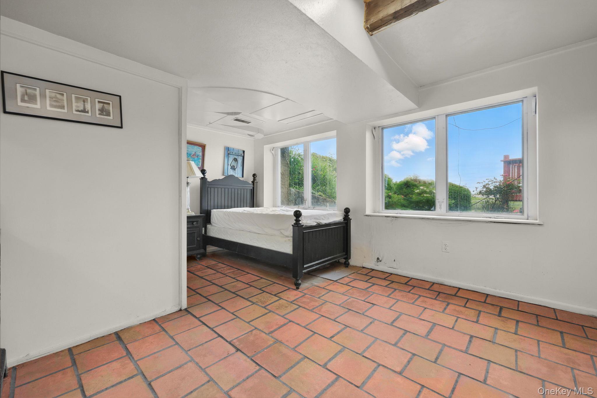 69 Cornwells Beach Road Sands Point, NY 11050 - Photo 10 of 42 a bedroom with a bed and a large window