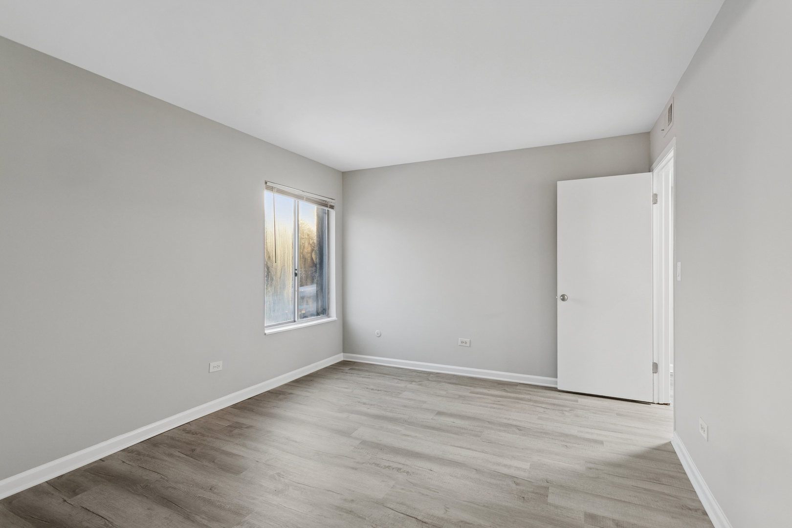 6185 Pinewood Court, Unit 202 Willowbrook, IL 60527 - Photo 9 of 20 a view of an empty room with wooden floor and a window