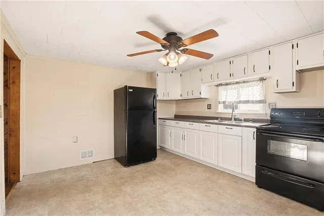 a kitchen with a refrigerator a sink and cabinets