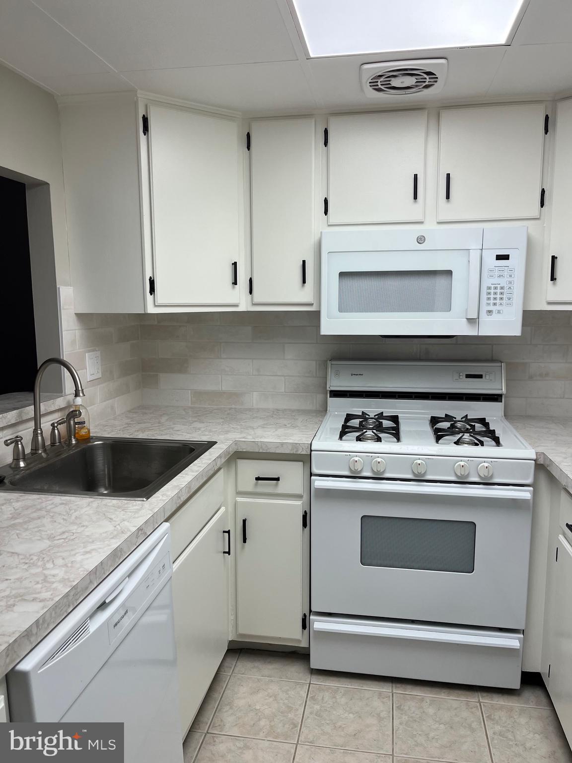 18204-00 Delaire Landing Road, Unit 204 Philadelphia, PA 19114 - Photo 11 of 14 a kitchen with white cabinets and white appliances