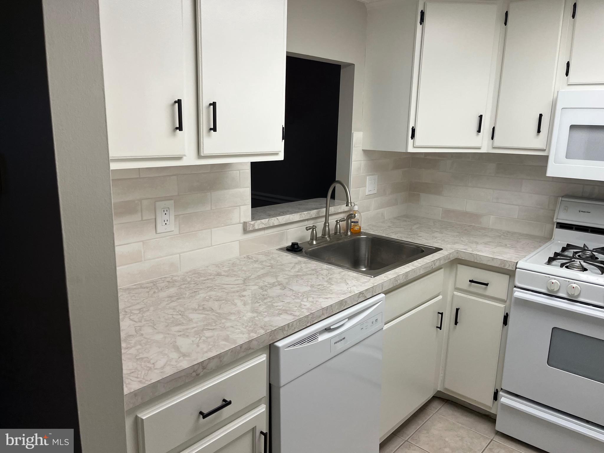 18204-00 Delaire Landing Road, Unit 204 Philadelphia, PA 19114 - Photo 12 of 14 a kitchen with granite countertop white cabinets and sink