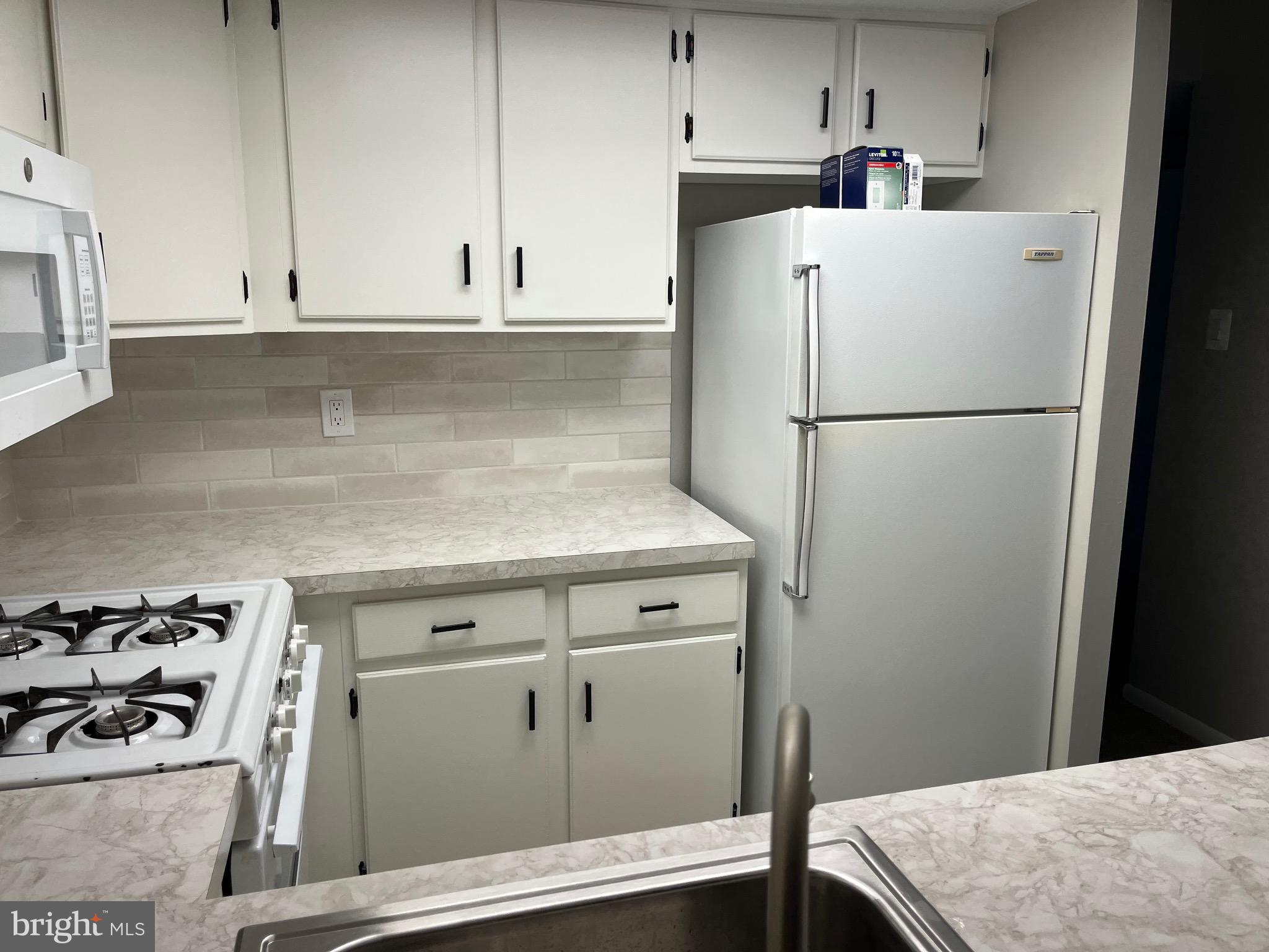 18204-00 Delaire Landing Road, Unit 204 Philadelphia, PA 19114 - Photo 13 of 14 a white refrigerator freezer sitting inside of a kitchen