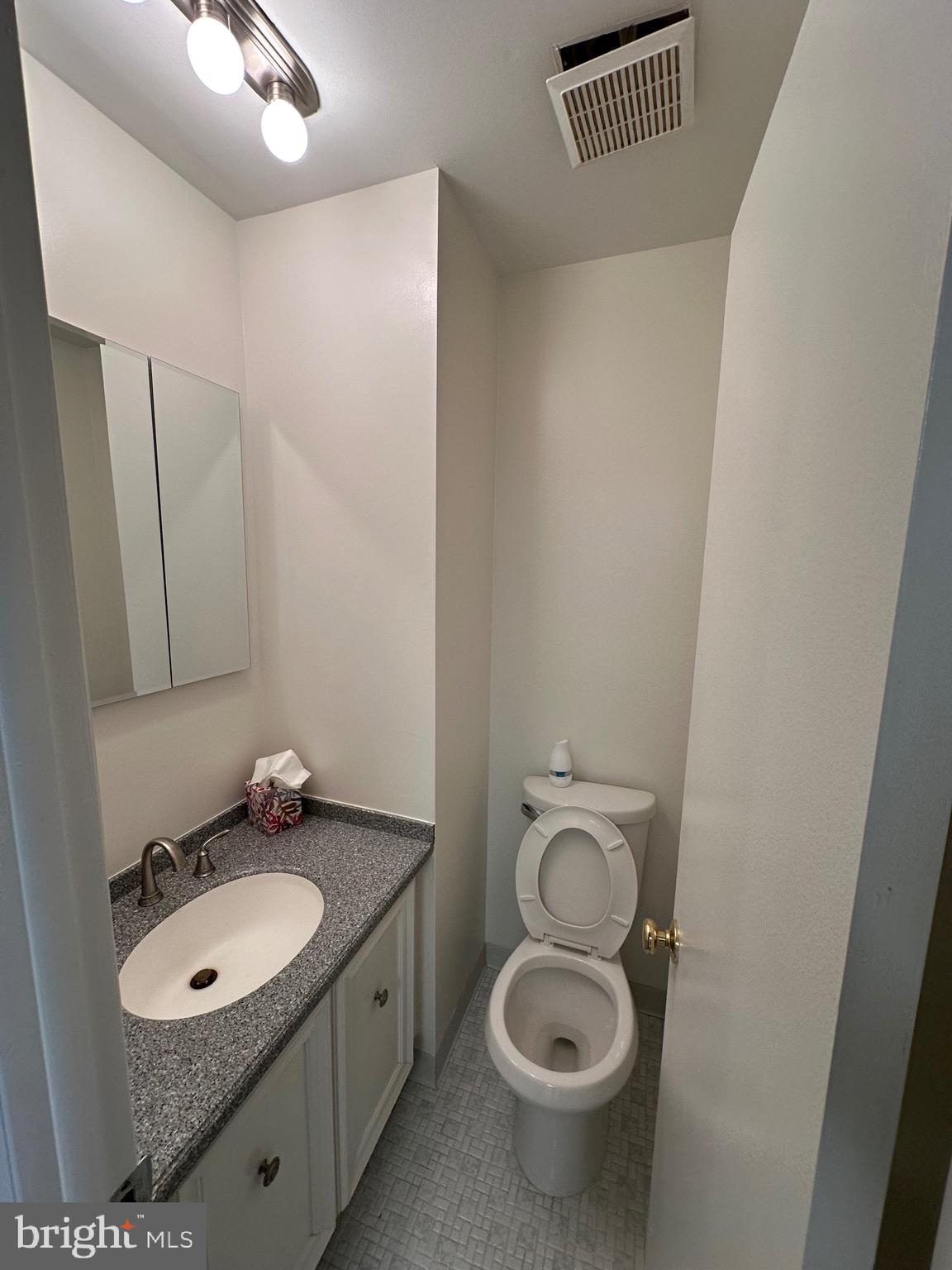 18204-00 Delaire Landing Road, Unit 204 Philadelphia, PA 19114 - Photo 10 of 14 a bathroom with a granite countertop sink toilet and mirror