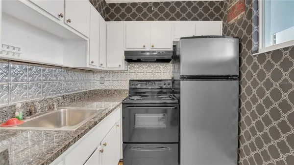 a kitchen with stainless steel appliances granite countertop a sink stove and microwave