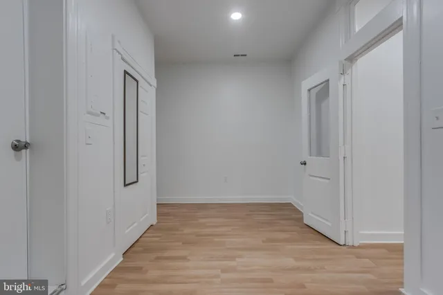 a view of an empty room with wooden floor