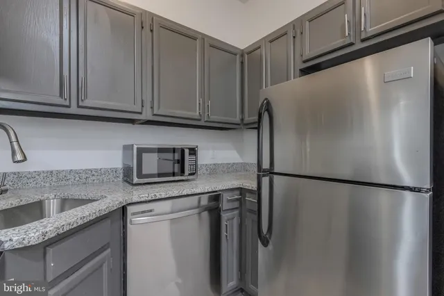 a kitchen with stainless steel appliances granite countertop a refrigerator and a sink