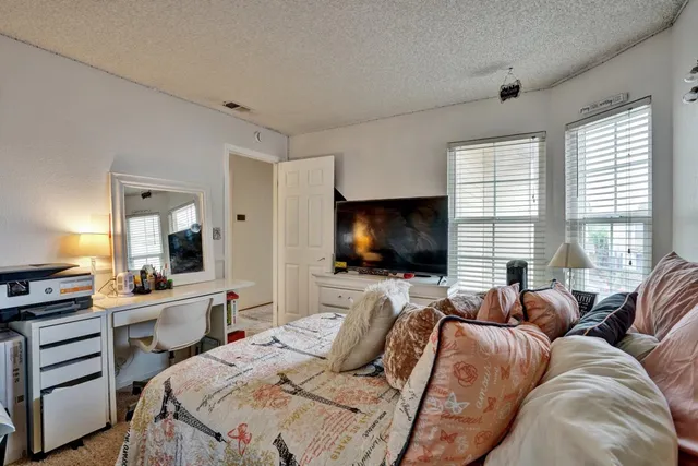 a bedroom with a bed and a flat screen tv