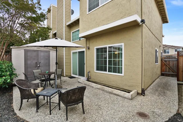 a patio with a table and chairs under an umbrella