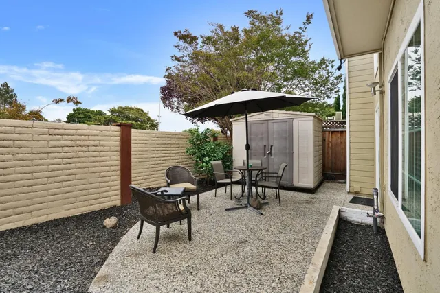 a view of a patio with a table and chairs under an umbrella