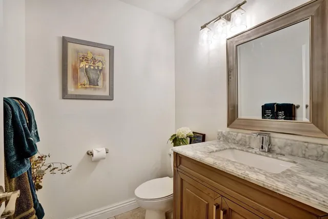 a bathroom with a granite countertop sink a toilet and a mirror