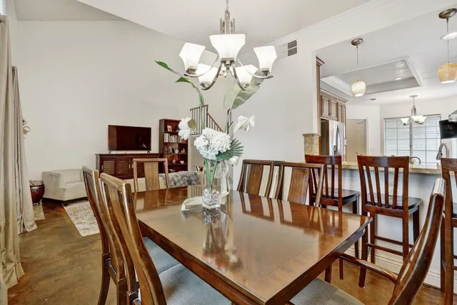 a view of a dining room with furniture a chandelier and wooden floor