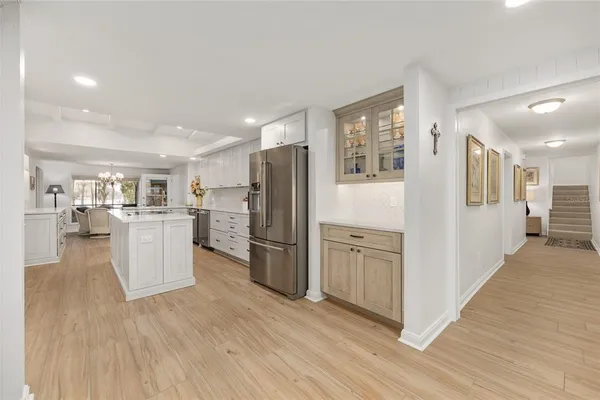a kitchen that has a lot of white cabinets and stainless steel appliances