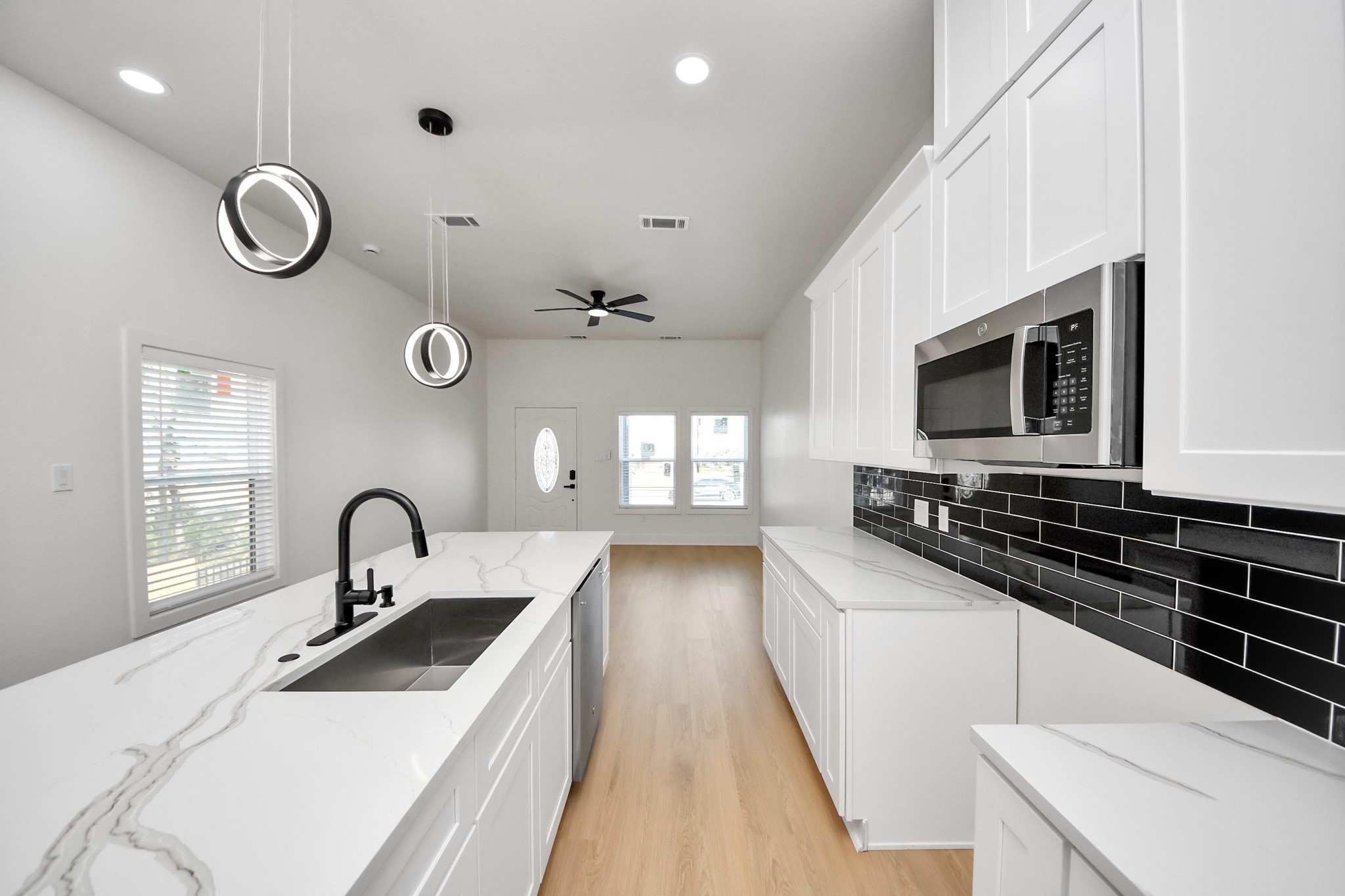 5226 Ricky Street Houston, TX 77033 - Photo 19 of 50 a kitchen with stove a sink and dishwasher with wooden floor