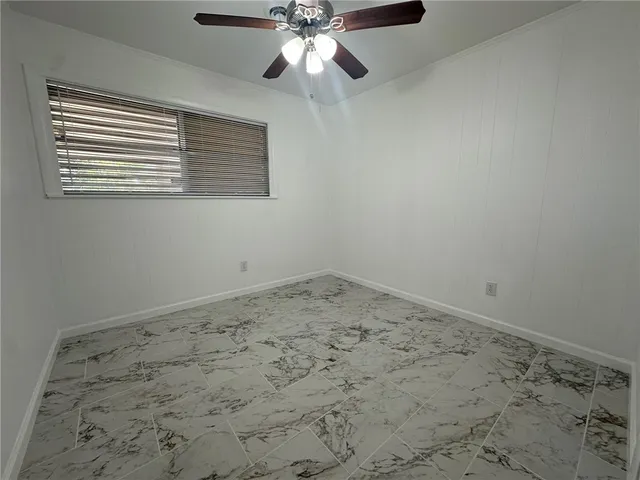 an empty room with a chandelier fan