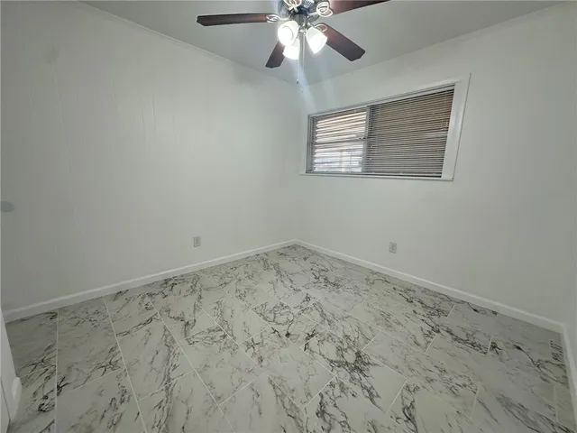 an empty room with a ceiling fan and a window