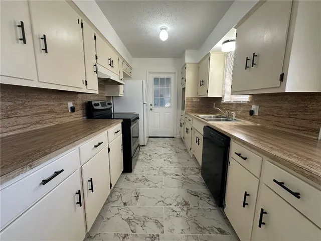 a kitchen with white cabinets and a sink
