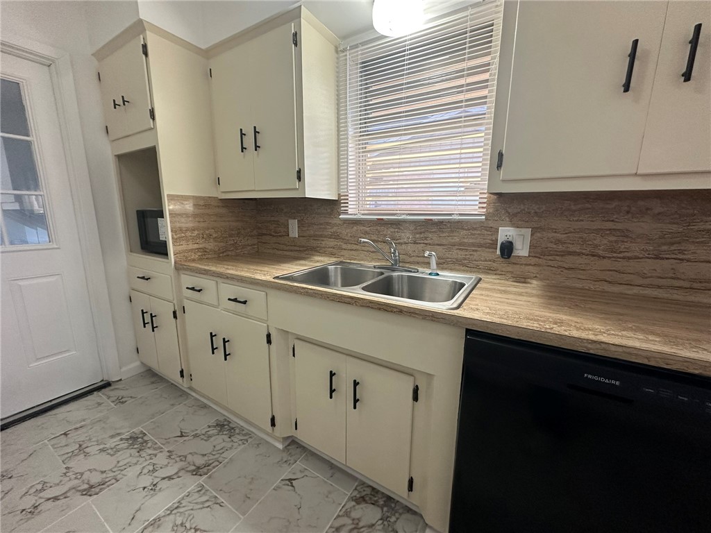136 Daniel Moore Avenue Portland, TX 78374 - Photo 8 of 40 a kitchen with white cabinets and a sink