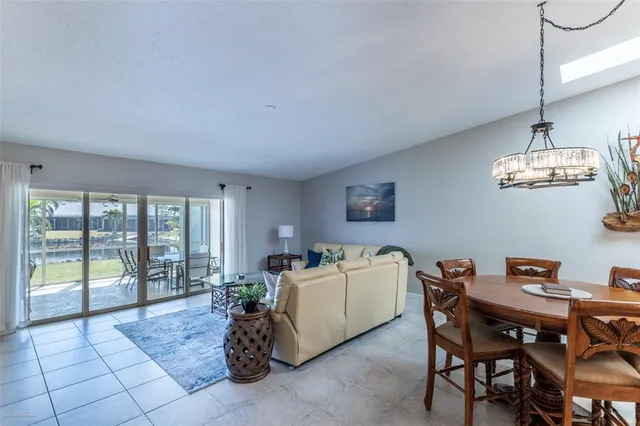 a dining room with furniture and a floor to ceiling window