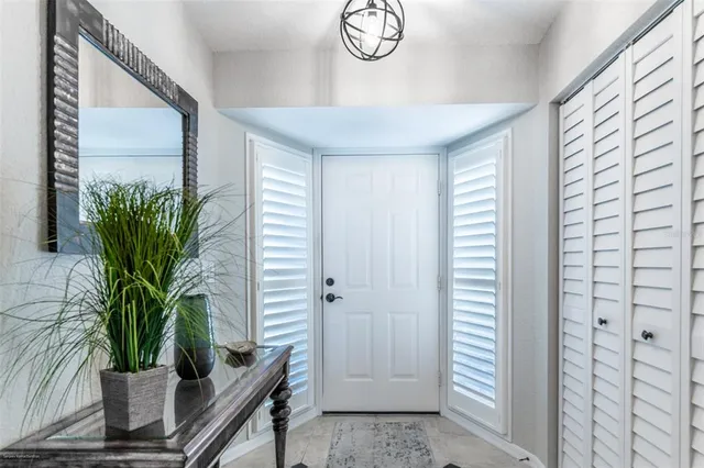 a kitchen with stainless steel appliances granite countertop a stove top oven a refrigerator a sink and chairs