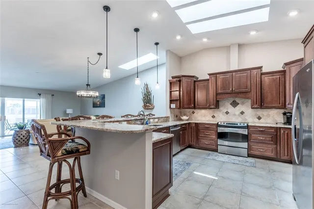 a kitchen with stainless steel appliances granite countertop a refrigerator stove and sink