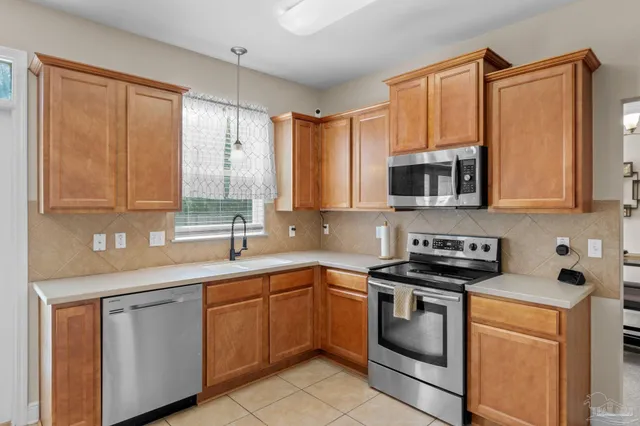 a kitchen with stainless steel appliances granite countertop white cabinets a sink and a stove