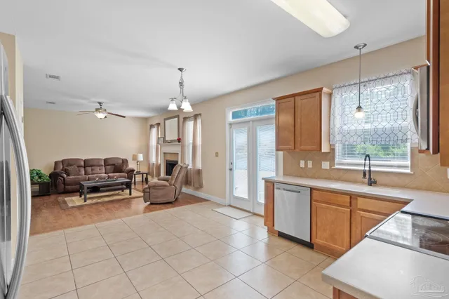 a large white kitchen with a large window and stainless steel appliances