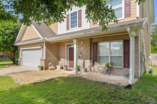 a view of a house with backyard and sitting area