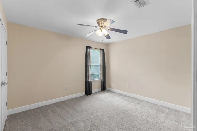 an empty room with a window and a fan