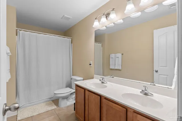 a bathroom with a double vanity sink mirror and toilet